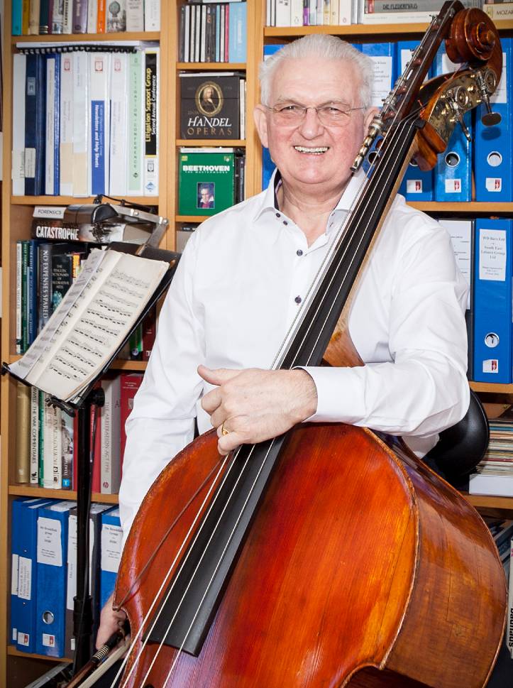 Chris Makin stood with his double bass in his office