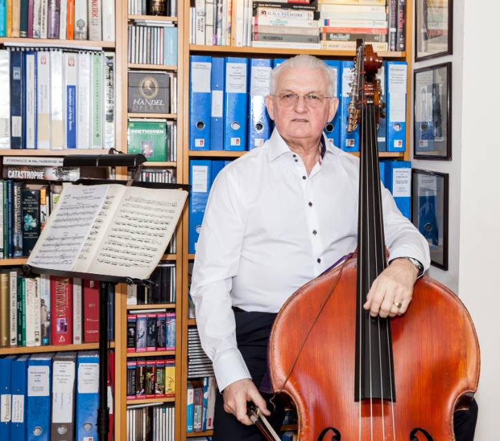 Chris Makin stood with his double bass in his office