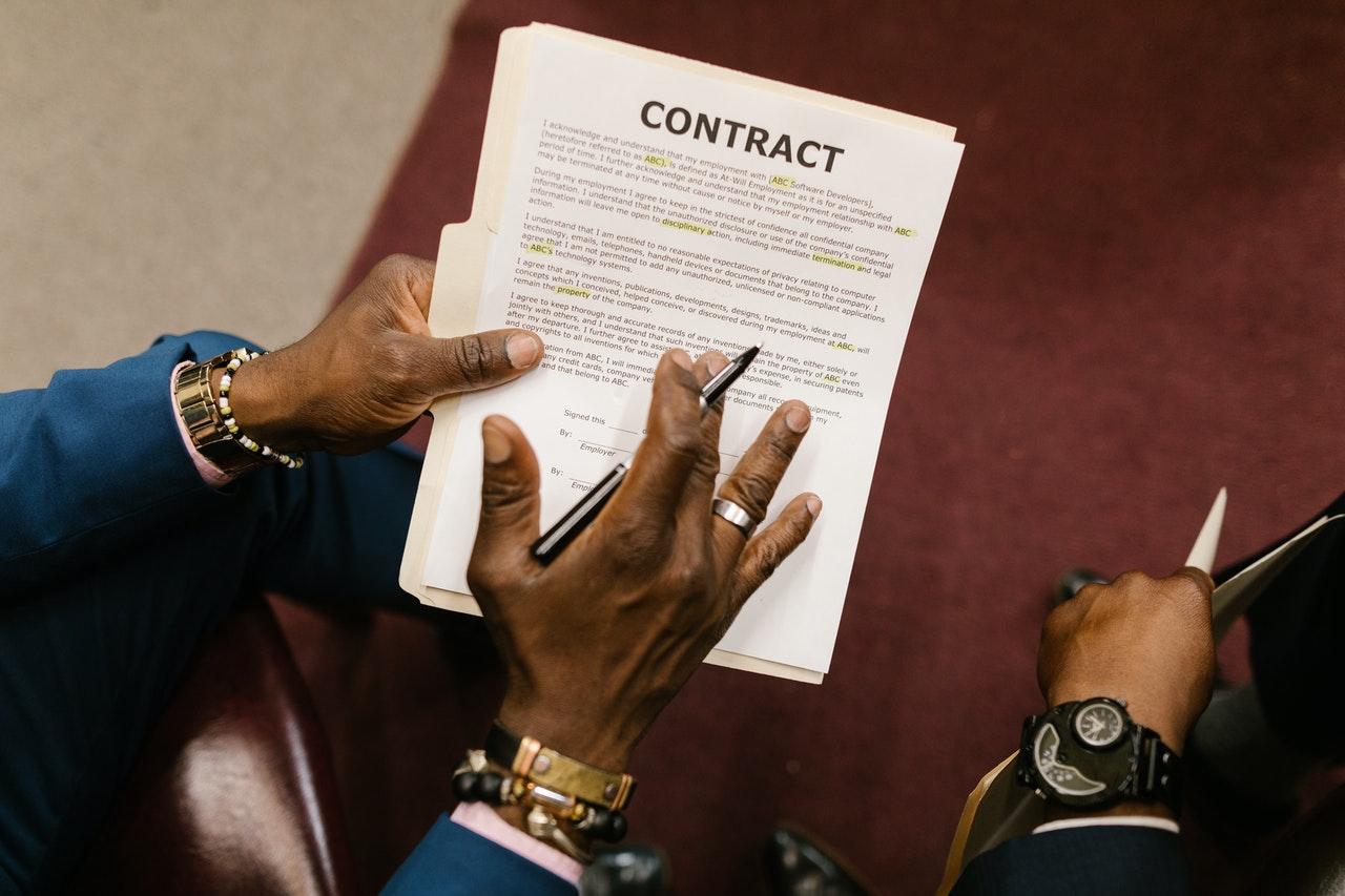 man holding a contract with highlighted sections
